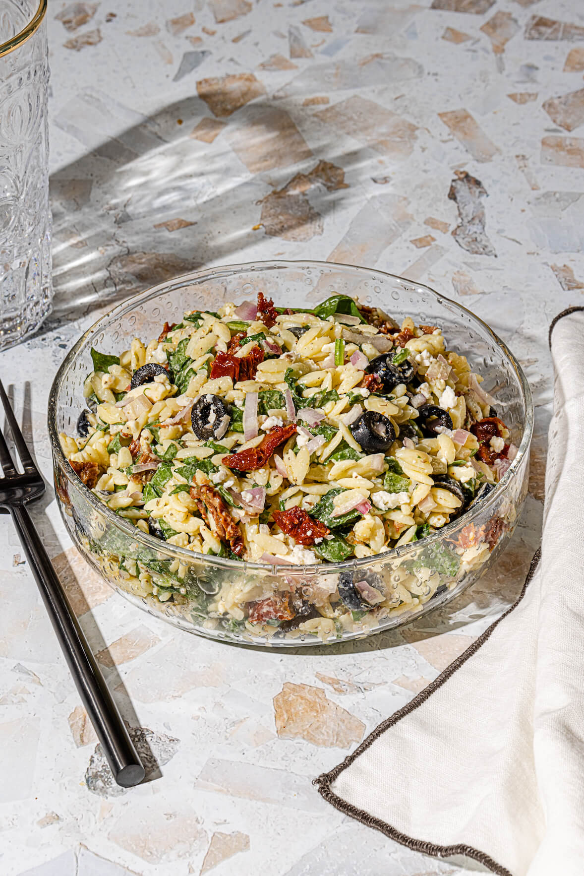 Salade d'orzo et vinaigrette grecque avec tomates séchées et olives noires tranchées